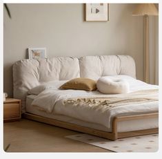 a white bed with pillows on it in a room