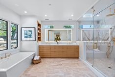 a large bathroom with two sinks and a bathtub next to a walk in shower