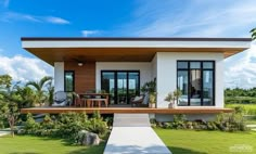 a modern house with an open floor plan and large windows on the front porch, surrounded by lush greenery