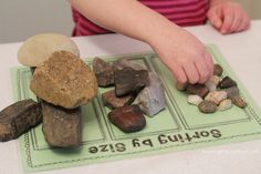 a child is playing with rocks on the table