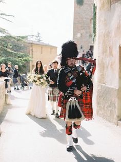 a man in a kilt walking down the street