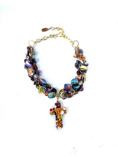 Elevate your style with this exquisite necklace, meticulously crafted with lustrous freshwater shells in a harmonious blend of golden hues and the enchanting shimmer of aurora borealis. Complementing this natural beauty is a magnificent handblown Murano glass cross, artfully designed to match the iridescent allure of the shells. Suspended gracefully, the cross gracefully dangles 2 inches in length. The necklace itself measures a versatile 18 inches, with the added convenience of adjusting its length to 16 inches, ensuring a perfect fit for any occasion. This remarkable piece effortlessly transitions from casual to elegant settings, pairing seamlessly with both your favorite jeans and a glamorous evening ensemble. Securing this unique treasure is a user-friendly hook and chain fastening, ma Shells Necklace, Glass Cross, Artfully Designed, Creating Jewelry, Style And Grace, Odessa, Aurora Borealis, The Cross, Murano Glass