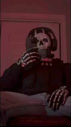 a person in a skeleton mask sitting on a bed