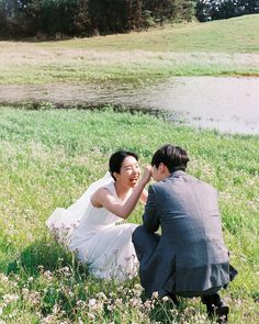 a man kneeling down next to a woman in a field