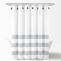 a white and grey shower curtain with black tassels on the top, in front of a white background