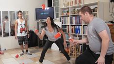 a group of people in a living room playing with nintendo wii motes and bowling balls