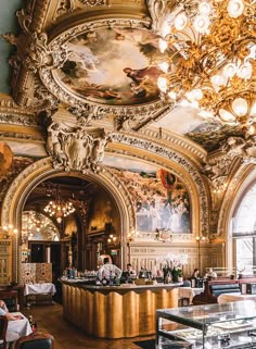 an ornately decorated restaurant with chandeliers and paintings