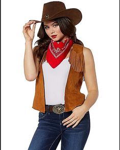 a woman wearing a cowboy hat, vest and bandana with her hands on her hips