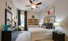 a bedroom with a bed, dresser and ceiling fan in it's center area