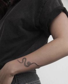 a woman with a snake tattoo on her arm