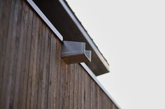 the corner of a wooden building with metal brackets on it