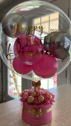 a birthday cake with balloons and flowers in it