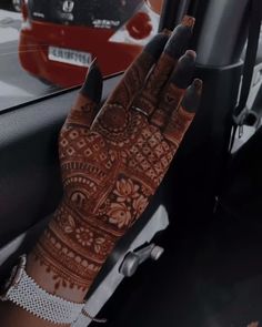 a woman's hand with hendix on it sitting in the passenger seat of a car