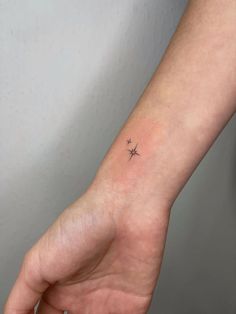 a small star tattoo on the wrist is shown in this image, it looks like an arrow