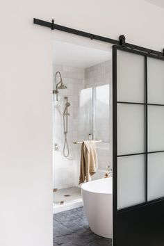 an open door leading to a bathroom with a bathtub and shower