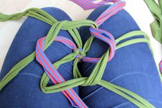 a pair of blue jeans tied together with pink and green ribbons on the back of them