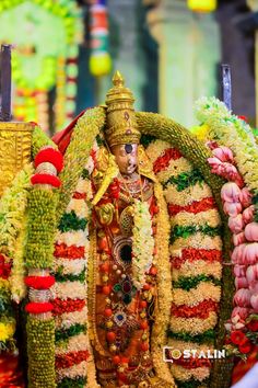 the statue is decorated with flowers and garlands