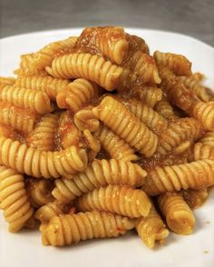 some pasta on a white plate with sauce