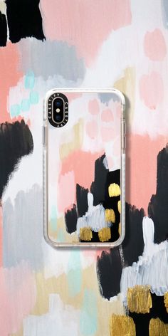 an iphone case with gold and black paint strokes on it, against a pink background