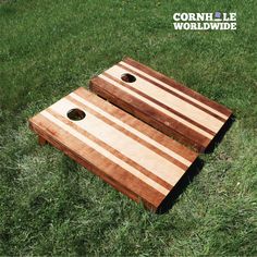 two wooden boards sitting in the grass with holes cut out to make them look like they are