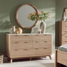 a room with a dresser, mirror and vase on the table in front of it