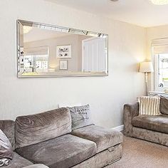 a living room filled with furniture and a large mirror