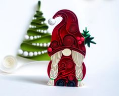 an ornament shaped like a gnome next to a christmas tree