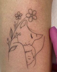 a woman's leg with a tattoo on it that has flowers and a dog