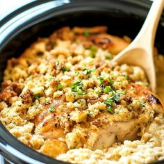 chicken and rice casserole in a crock pot with a wooden spoon