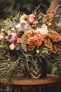 an arrangement of flowers is sitting on a chair