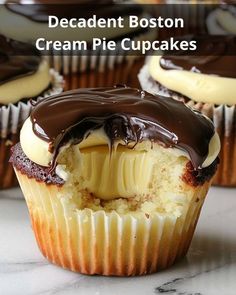 some cupcakes with white frosting and chocolate drizzle