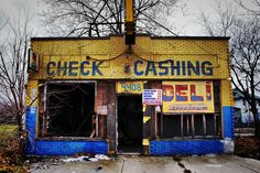 an old building that has been painted blue and yellow with the words check cashing on it