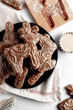 some cookies are on a black plate next to cookie cutters