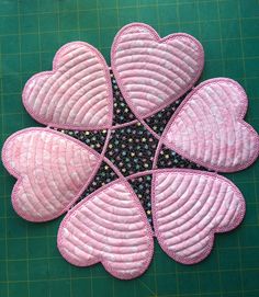 a close up of a pink flower on a green table with black and white squares