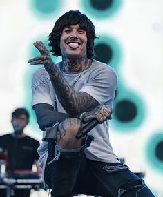 a man with tattoos on his arms and legs, sitting in front of a microphone