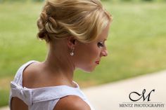 a woman with blonde hair wearing a white dress and earrings looking off into the distance