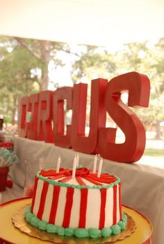 a red and white cake sitting on top of a table next to a wooden sign