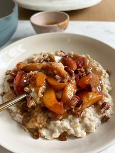 a white plate topped with oatmeal and fruit