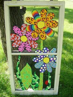 an old window is decorated with colorful flowers