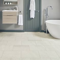 a white bath tub sitting next to a bathroom sink