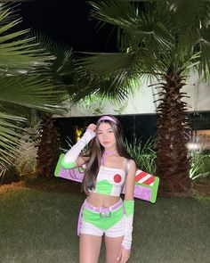 a woman in green and white outfit standing next to a palm tree