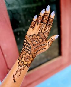 a woman's hand with henna tattoos on it