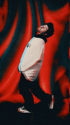 a man standing on top of a skateboard in front of a red and blue background