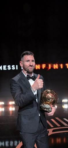 a man in a tuxedo holding a soccer ball