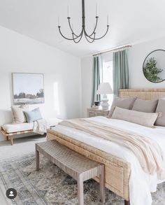 a bedroom with a large bed and a chandelier hanging from the ceiling above it