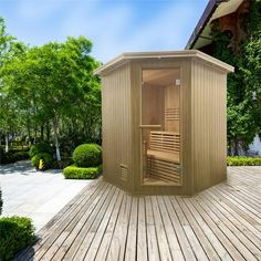 an outdoor sauna is shown in the middle of a wooden decked area with trees and bushes