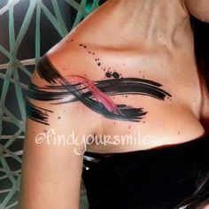 a woman with a tattoo on her back has a pink ribbon in the shape of an arrow