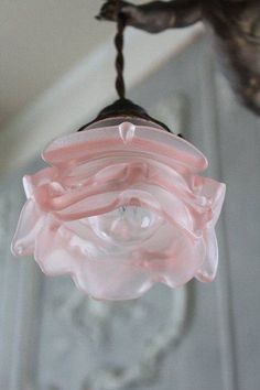 a pink light fixture hanging from a ceiling