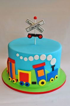 a birthday cake with a train theme on the top and nameplate that says convivor