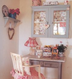 a desk and chair in a room next to a wall with pictures on the walls